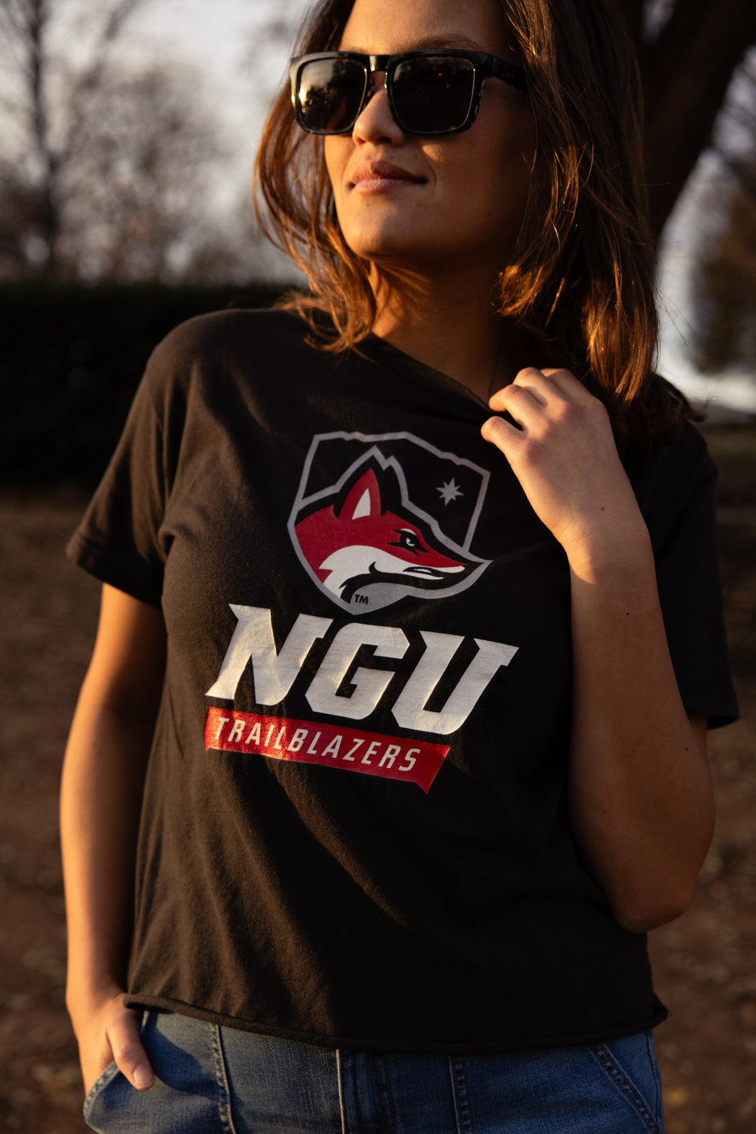 Person wearing a black t-shirt with 'NGU Trailblazers' logo outdoors