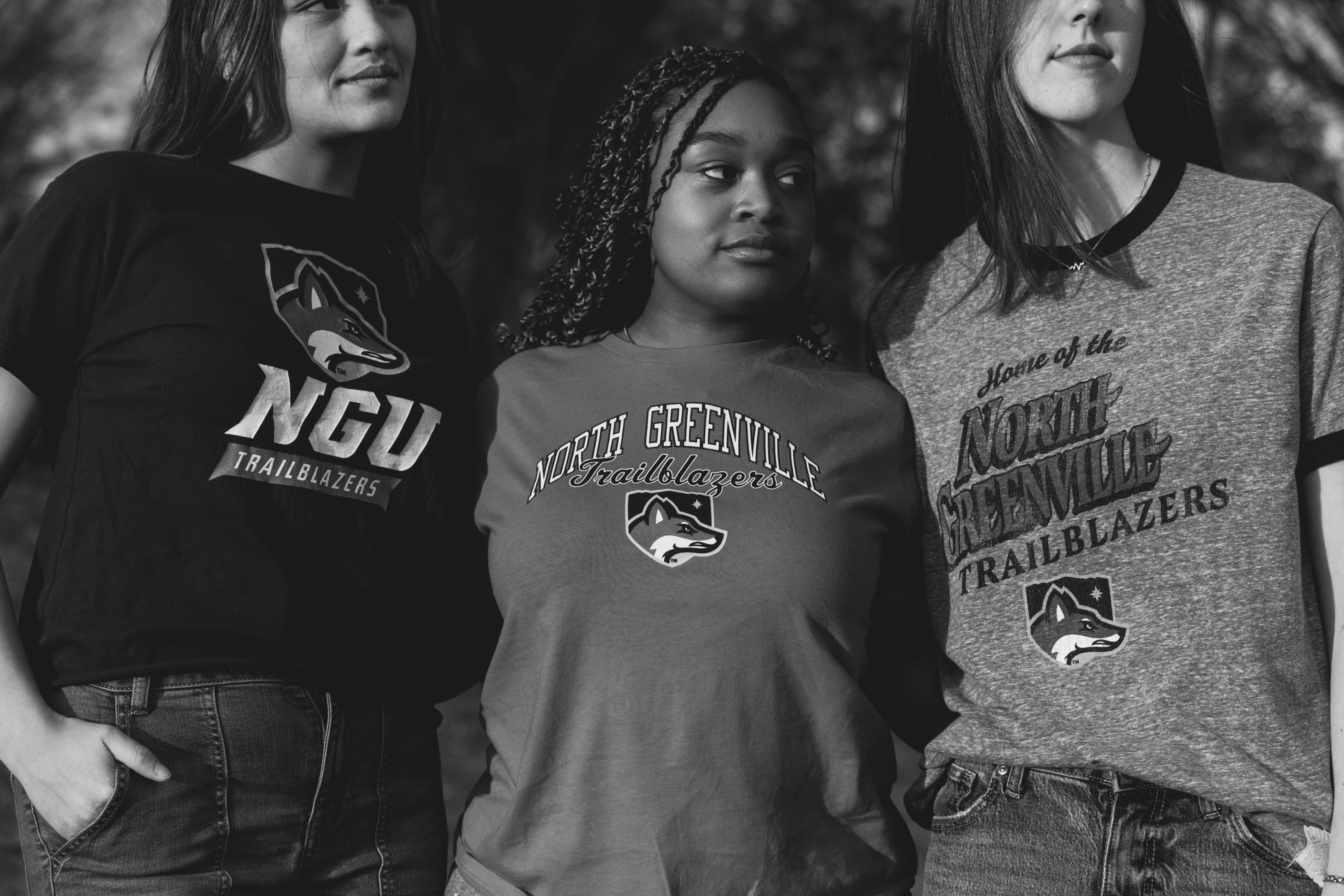Three people wearing North Greenville University t-shirts with a logo.